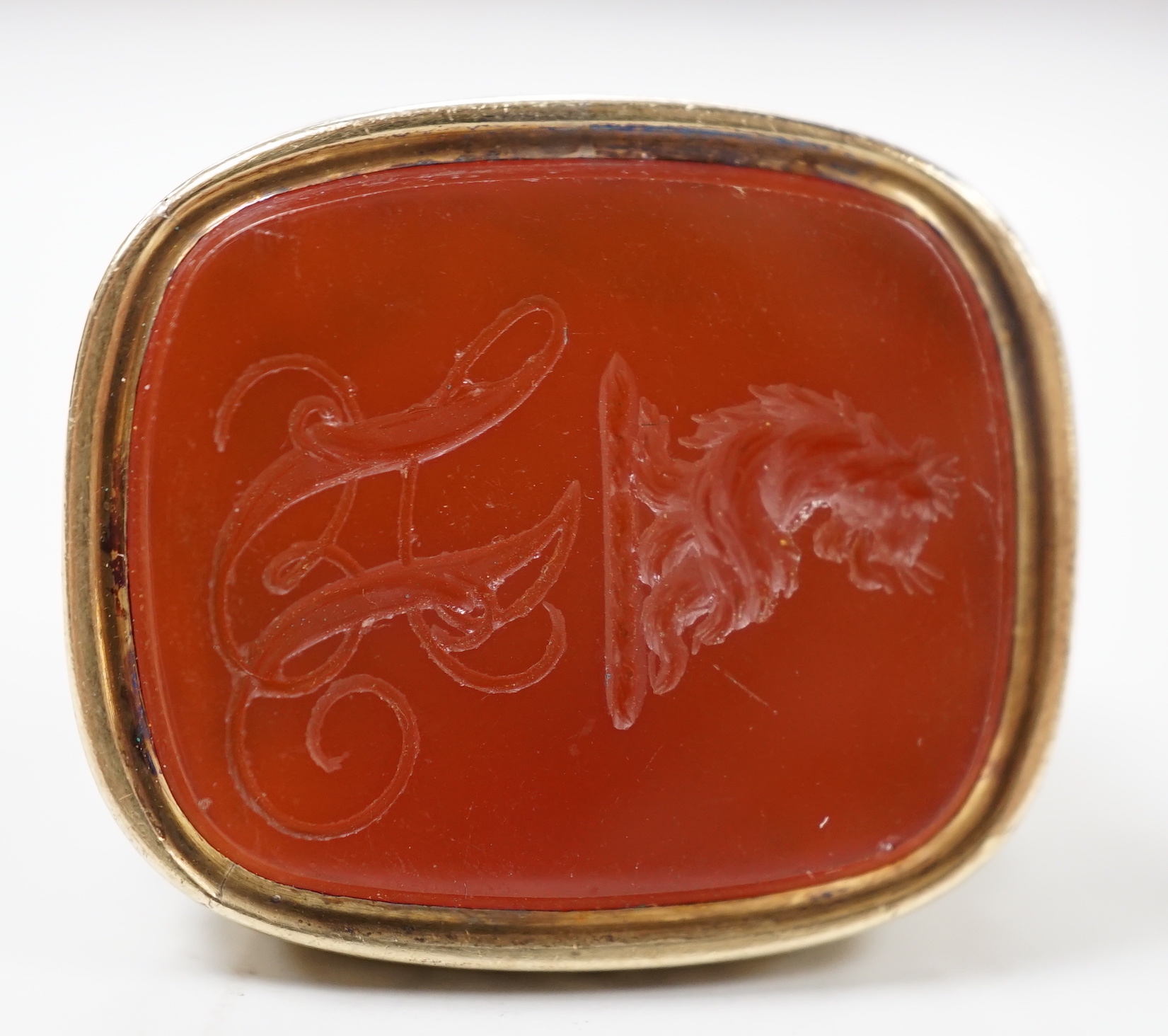 A 19th century yellow metal overlaid and carnelian set fob seal, the matrix carved with crest and monogram, 37mm.